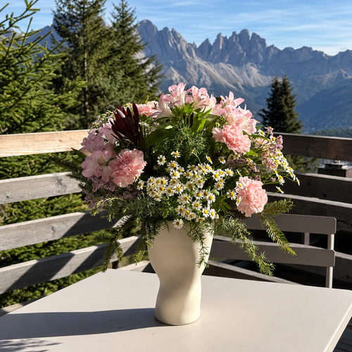 SŌL Vase mit rosa Blumen auf einer Terrasse vor Bergen