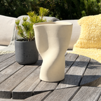 SŌL Vase auf einem Holztisch vor einer Sitzecke auf der Terrasse